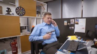 Maakler kontoris telefoniga rääkimas